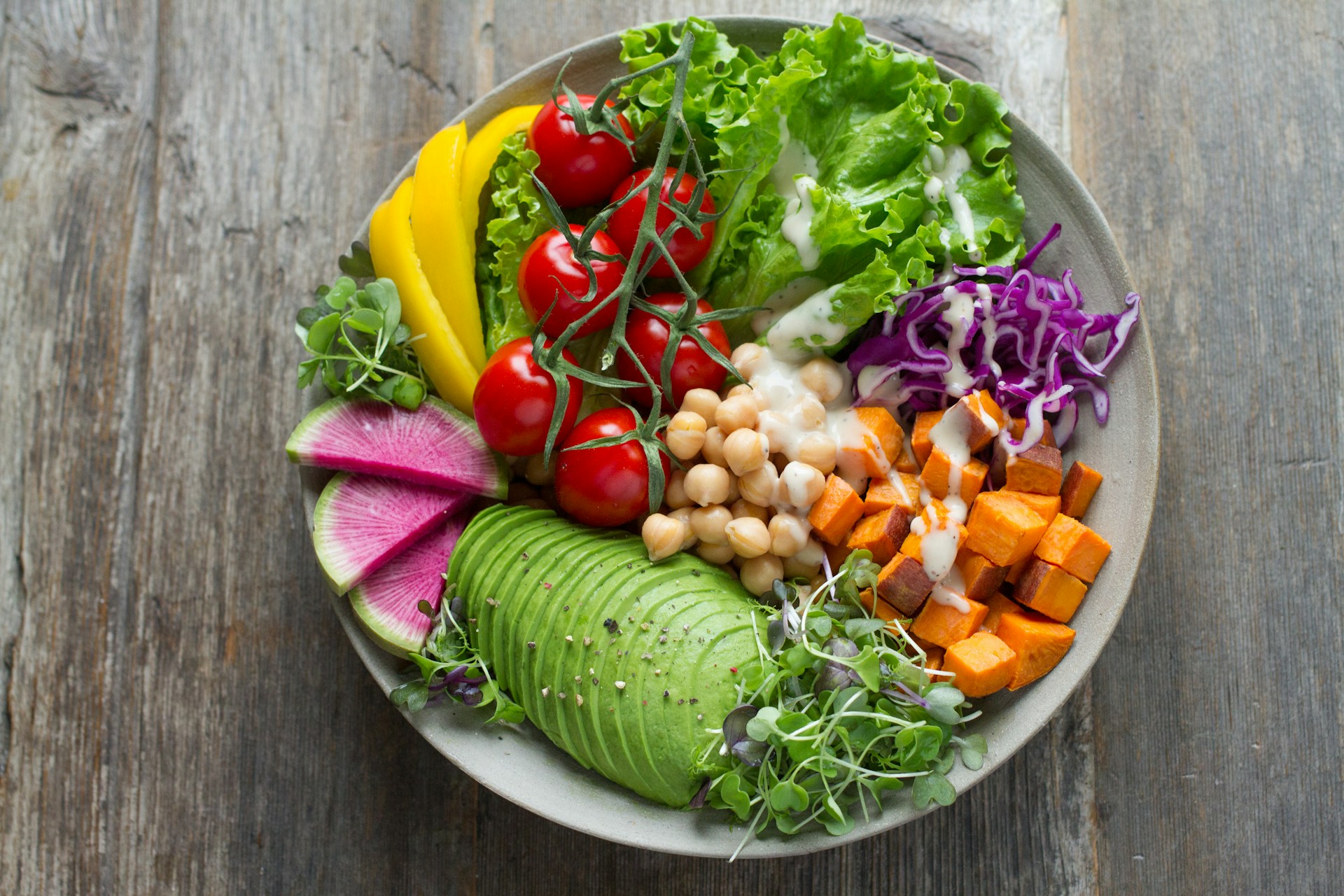 Bol de ensalada colorida con verduras frescas sobre una mesa