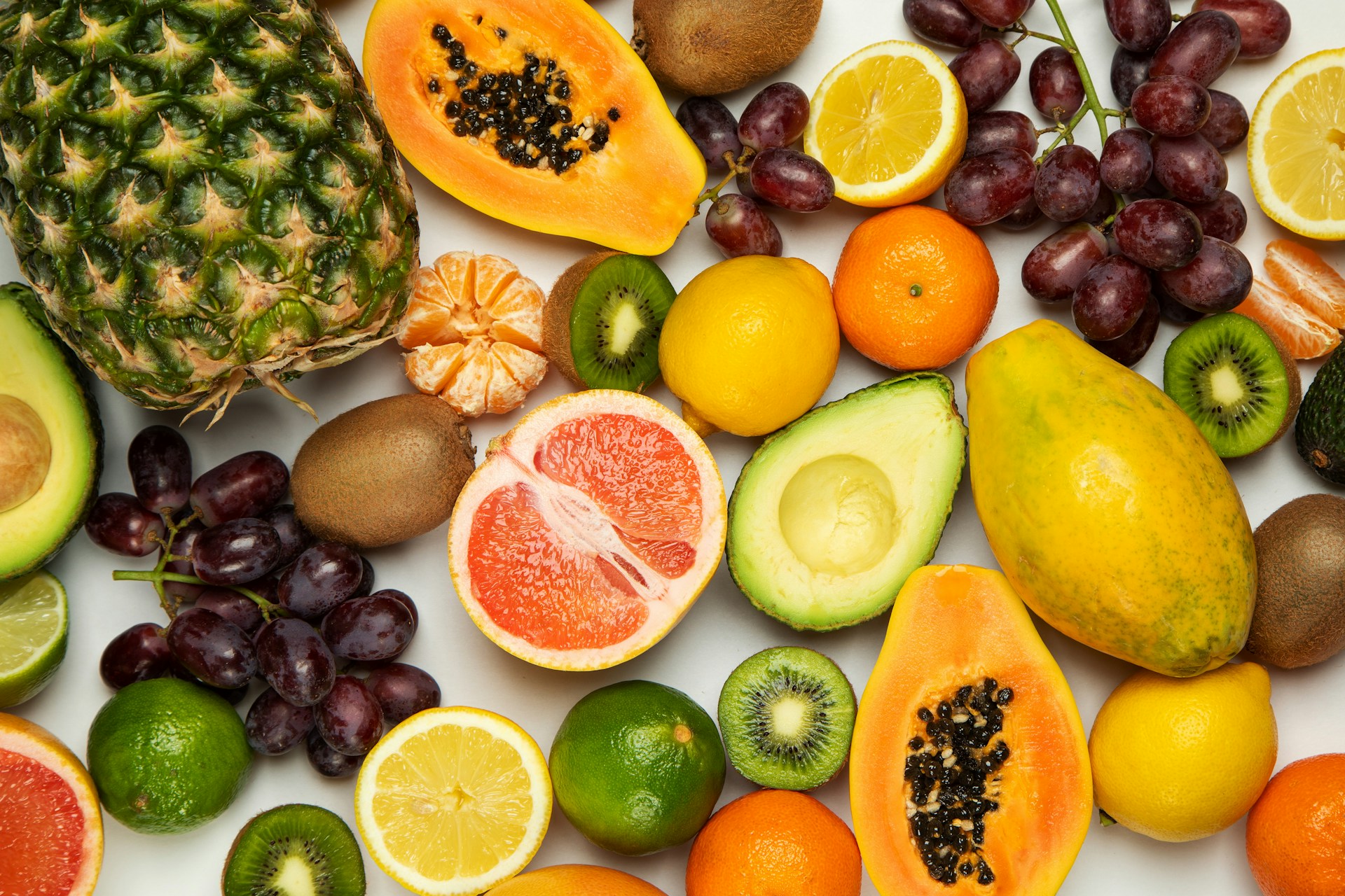 Frutas y verduras frescas y coloridas sobre una superficie blanca