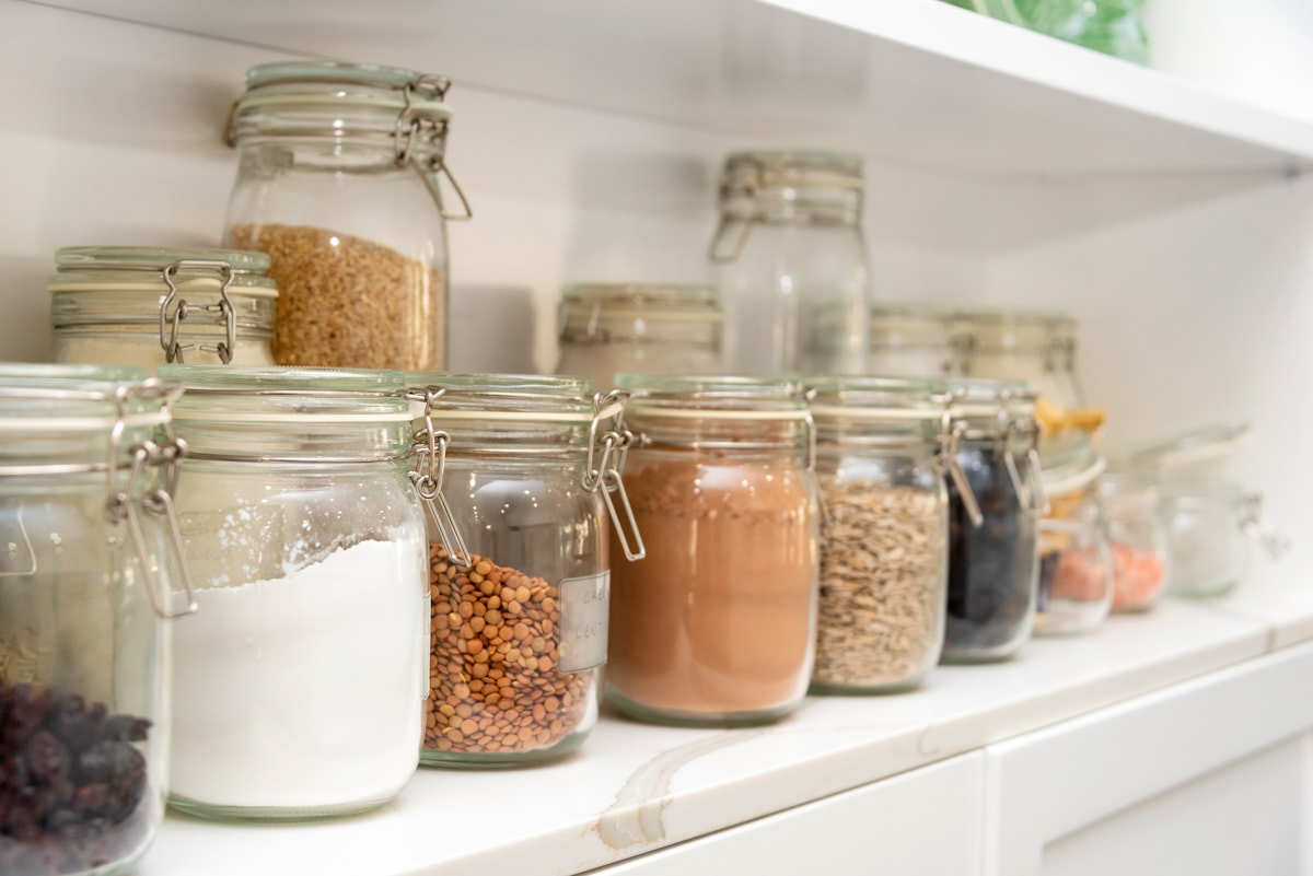 Row of glass jars with dry goods neatly organized on shelves